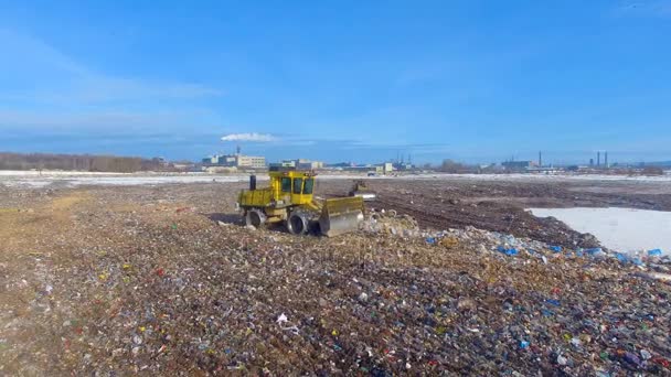 La excavadora empujando la basura al vertedero. Un helicóptero. 4K . — Vídeos de Stock