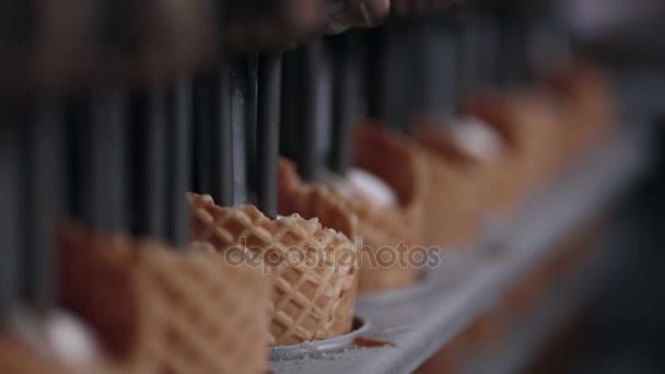 La prise de vue rapprochée de la machine remplissant les cônes de crème glacée de crème glacée. HD . — Video