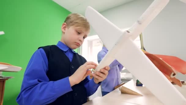 Meninos da escola primária montando modelos de construtor do avião e o modelo do foguete. 4K . — Vídeo de Stock