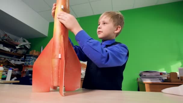 男孩看着火箭模型。4 k. — 图库视频影像