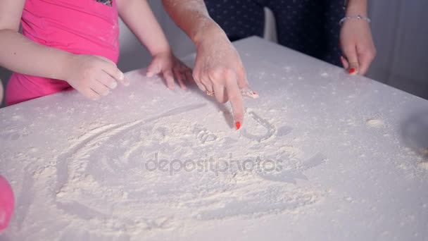 Donna irriconoscibile e il bambino disegnano il cuore sul tavolo della cucina. Primo piano. HD . — Video Stock