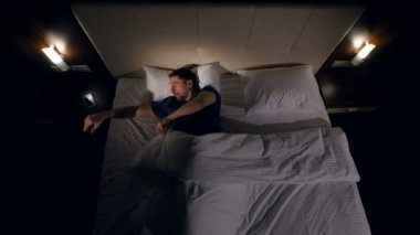 Karanlıkta yatakta yalan smartphone kullanan adam. 4k.