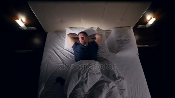De opnames van bovenaf van de man probeert te gaan om te slapen. 4k. — Stockvideo