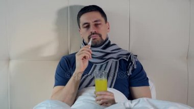 Hastalıklı bir adam vücut ısısı alıyor. Yakın çekim. 4k.