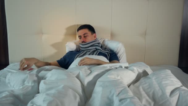 Zieke man blazen neus in bed. 4k. — Stockvideo