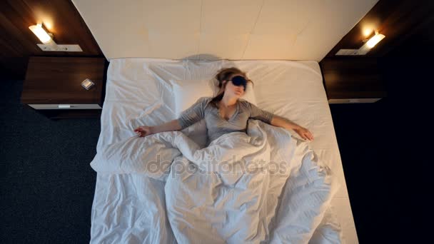 Женщина спит, бросает и разворачивается в постели. 4K . — стоковое видео