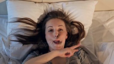 Neşeli kadın yatakta dans. Yakın çekim.