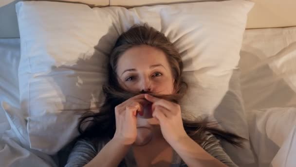 Veselá, šťastná žena grimas v posteli. 4k. — Stock video