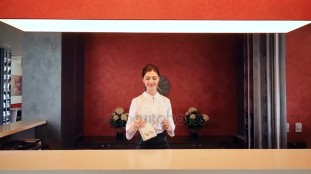 Receptionist greeting hotel guest, giving room key. 4K. — Stock Video