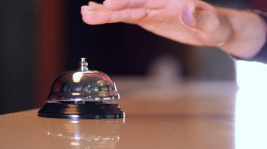 Kişi arama bir ahşap üzerine eski bir otel bell üzerinde stand ve çip anahtar otel odasından olsun. 4k.