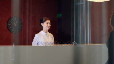 Otel lobisinde hizmet müdürüyle ziyaretçi karşılamaktadır. 4k.