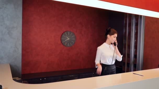 Freundliche Hotelrezeptionistin trifft Neuankömmlinge. 4k. — Stockvideo