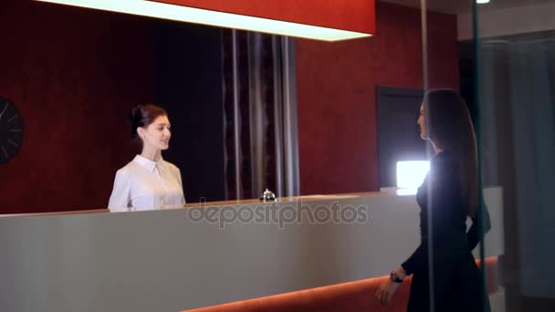 Менеджер гостиничного сервиса приветствует новую клиентку-бизнесвумен. 4K . — стоковое видео