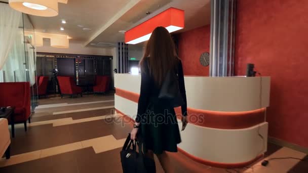 Businesswoman checking in at a reception desk. 4K. — Stock Video