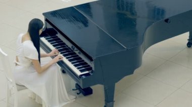 Kızı piyanist piyanoda. Yüzü yok. 4k.