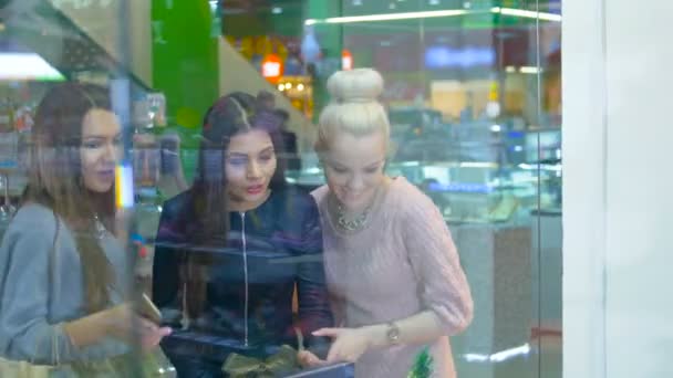 Beautiful woman friends looking at showcase in mall. 4K. — Stock Video