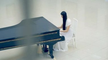 Kadın piyanist piyano beyaz elbise
