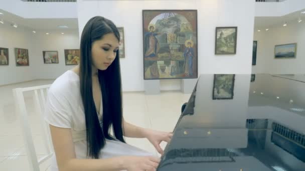 Жінка-піаністка грає на піаніно в художній галереї — стокове відео