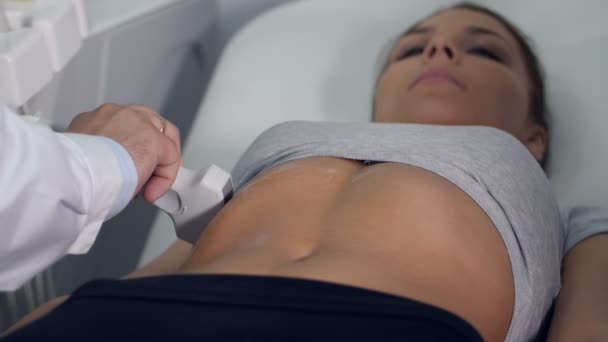 Лікар перевіряє шлунок дівчат ультразвуковим апаратом . — стокове відео