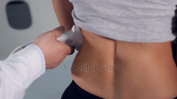 La paciente está recibiendo su espalda examinada por un dispositivo de ultrasonido. 4K . — Vídeos de Stock