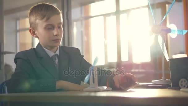 Un niño aprendiendo cómo la energía eólica puede convertirse en energía eléctrica . — Vídeo de stock