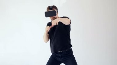Sanal gerçeklik kulaklık giyen ve yapmak bir adamın biriyle kavga taşır. Beyaz arka plan. 4k.
