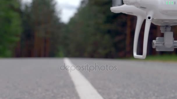 Un quadcopter volando por la carretera, cámara lenta . — Vídeos de Stock