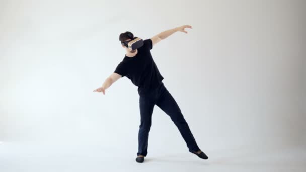 Un homme porte un casque de réalité virtuelle faisant des pas prudents. Fond blanc. 4K .