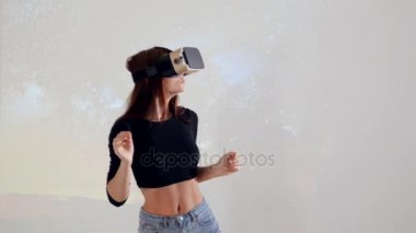 Bir kız sanal gerçeklik kulaklık eğlenerek etrafa giyiyor. Beyaz arka plan. 4k.