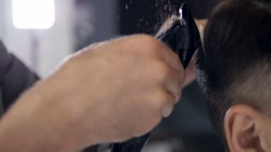 Yakın çekim. Bir adam bir saç kesimi teknik gerçekleştirme Kuaför. Çok yavaş hareket.