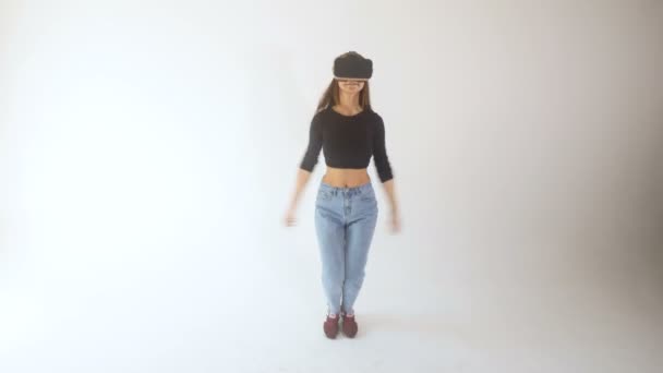 Diversión en realidad virtual. Una chica con auriculares VR y saltando mirando feliz . — Vídeos de Stock
