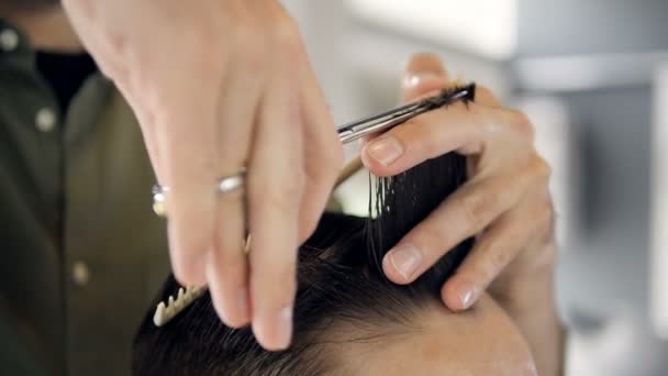 Hair stylist performing a haircut technique on a man. — Stock Video