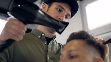 Kuaför Saç kurutma makinesi kullanarak bir saç modeli yapmak. Ağır çekim.