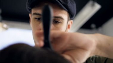 Saç kurutma makinesi kullanarak bir saç modeli ve bir fırça berber. Ağır çekim.