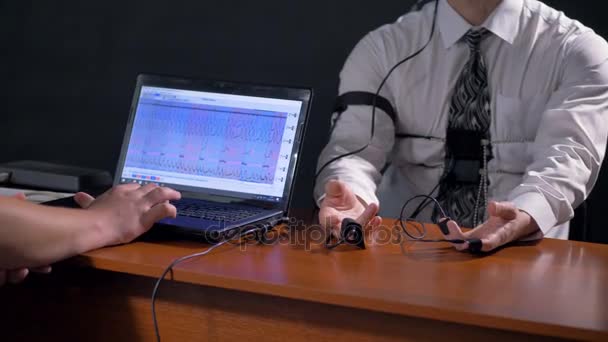 A polygraph computer screen beside operator and subjects hands. — Stock Video