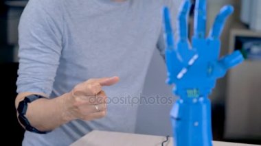 Kol bandı denetleyicisi giyen bir mühendis yön robot bir el verir.