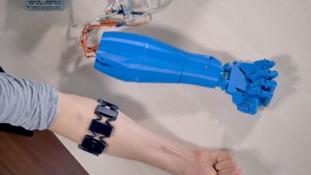 Un humain et une main bionique couchés les uns à côté des autres. Vue du dessus . — Video
