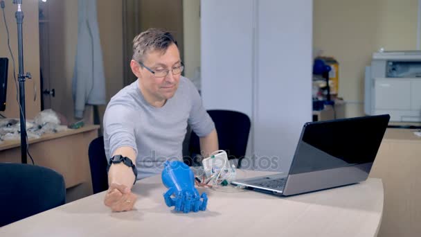 Inženýr učí prototyp bionickou ruku sevřít v pěst. — Stock video