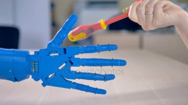 Bir tornavida bir biyonik el alır.