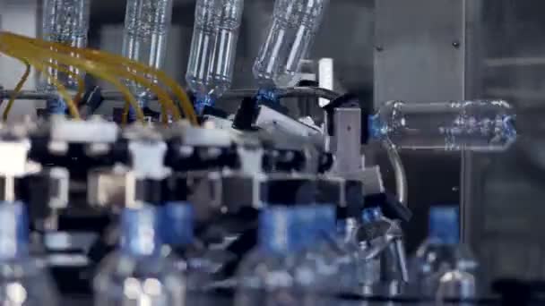 Многочисленные бутылки перевозятся на заводе по производству бутилированной воды . — стоковое видео