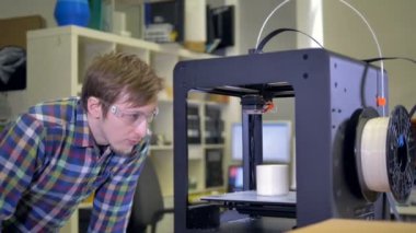 Adam 3d yazıcıdan ürün alıyor.