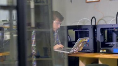 Çalışan bir dizüstü bilgisayar ve 3d yazıcılar. 4k.