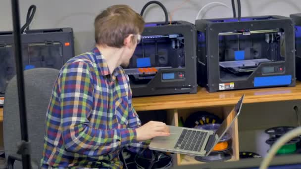 Работник контролирует процесс создания пластиковой модели. 3D-печать . — стоковое видео