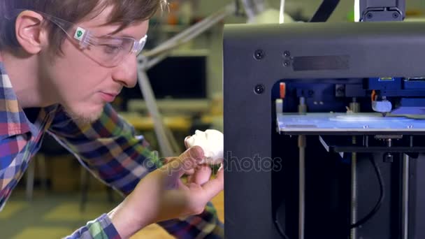 Ingenieur kijken naar de witte kop op 3D-printer afgedrukt. 4k. — Stockvideo