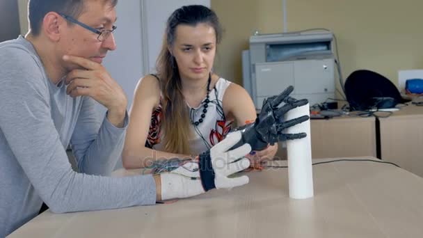 Een vrouw met bionische arm grijpen papieren handdoeken. — Stockvideo