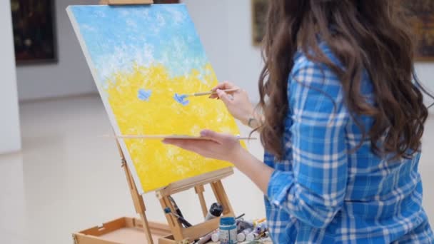 Κορίτσι ζωγραφική μια εικόνα χρησιμοποιώντας το μπλε χρώμα. — Αρχείο Βίντεο