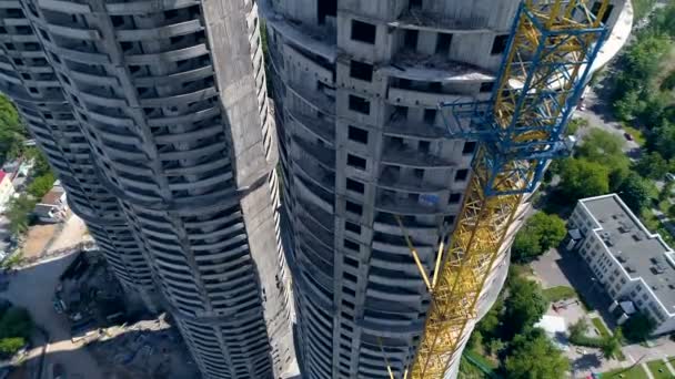 A round tower beside a crane with a small counterweight. — Stock Video