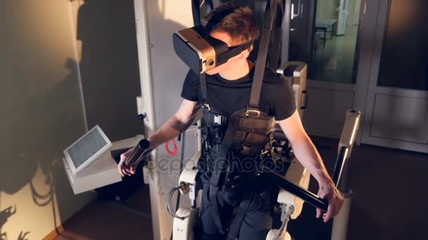 A férfi belsejében egy exoskeleton visel Vr fülhallgató. — Stock videók