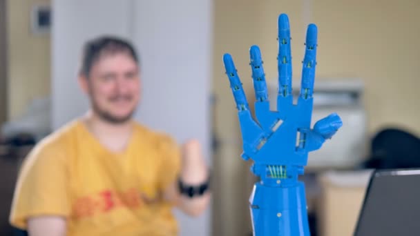 Bionische Hand bewegt sich und der Mann mit der amputierten Hand kontrolliert sie. — Stockvideo