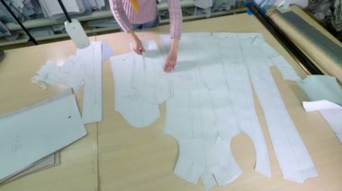 Bir kadın denetler ve kağıt kalıpları karşılaştırır.